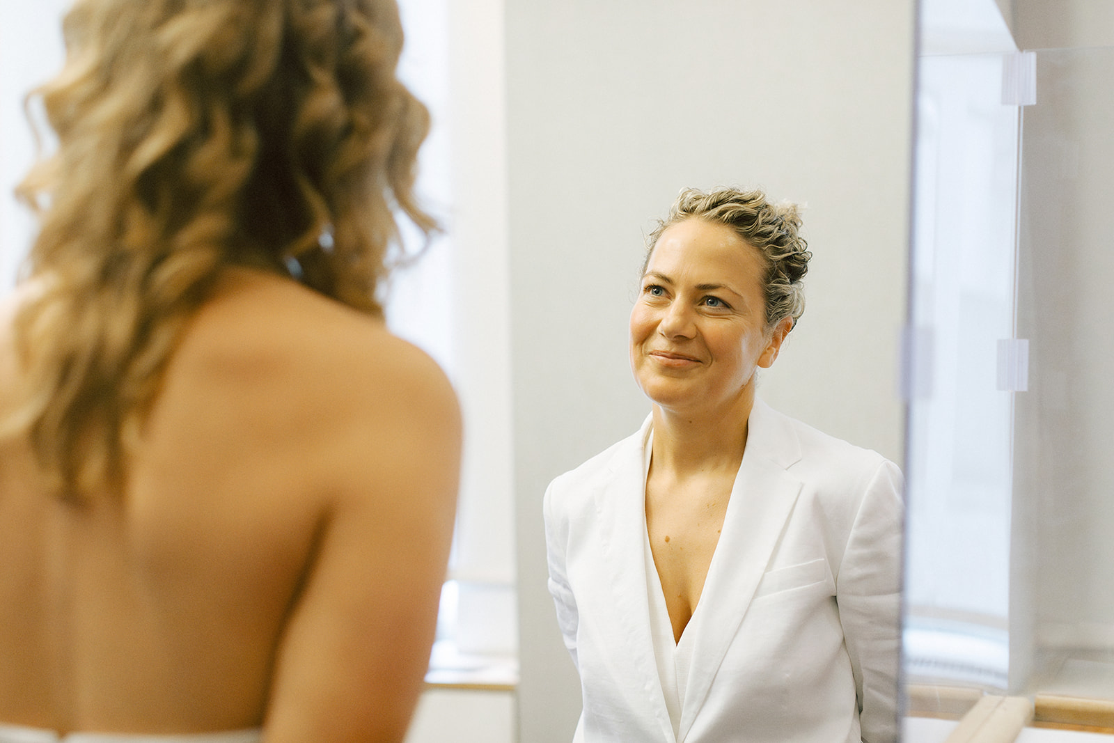 One bride looking lovingly at the other bride during their city hall elopement