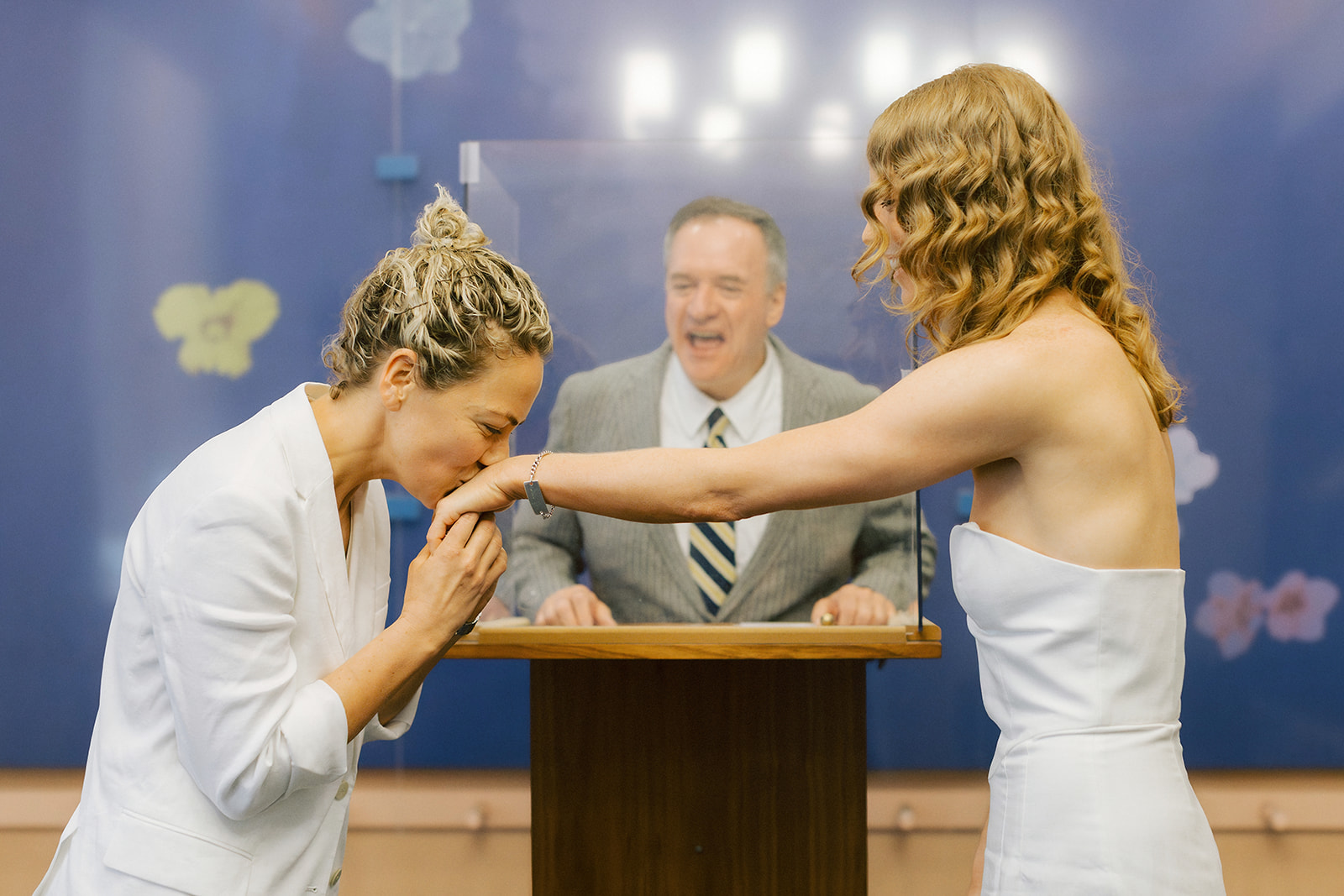 Photo from Catie and Jane's civil ceremony where one bride is kissing the other bride's hand during their city hall elopement