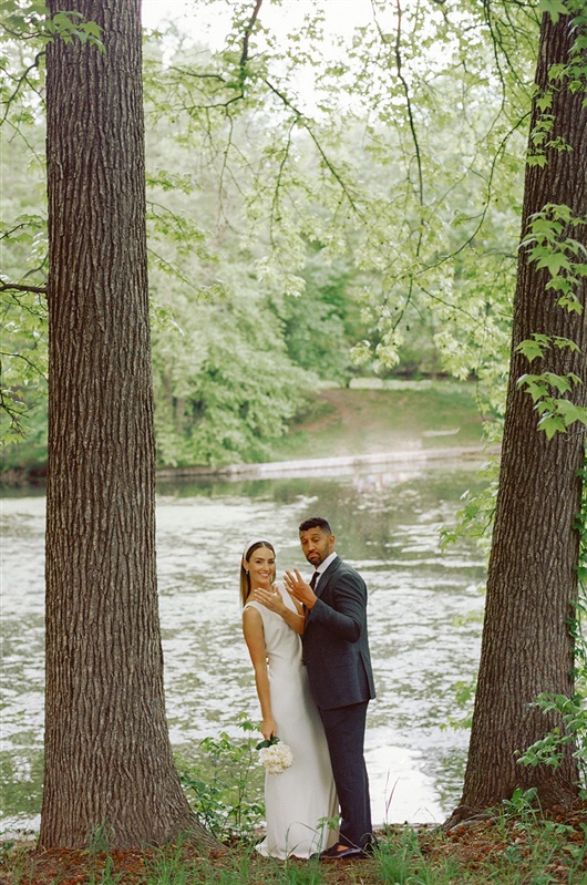 Bride and groom showing off their rings in between trees after Brooklyn civil ceremony