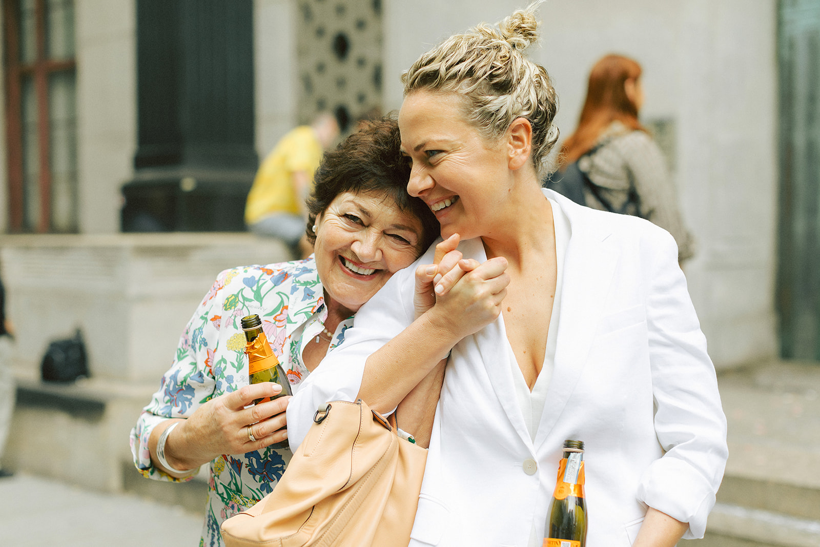 Bride holding hands with her mom outside of NYC city hall elopement to celebrate her marriage
