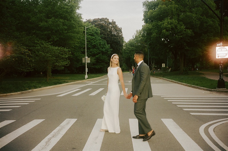 Bride and groom crossing the street walking through Prospect Park in Brooklyn after their civil ceremony