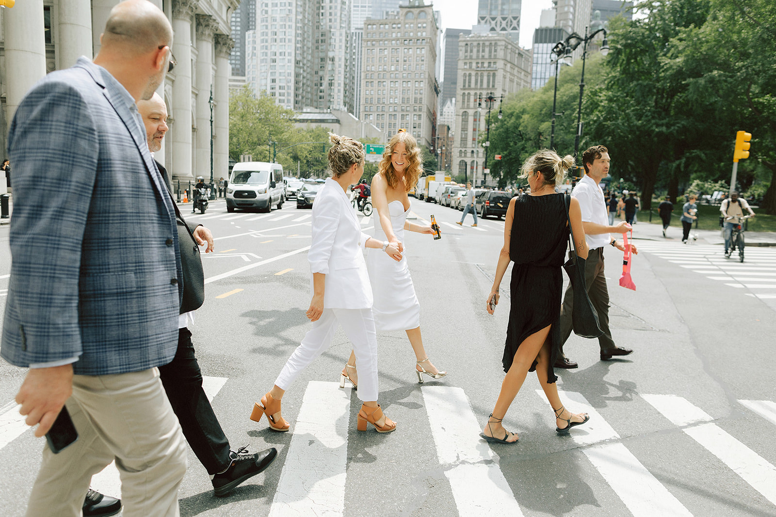 Couple holding hands walking across the street during city wedding photoshoot