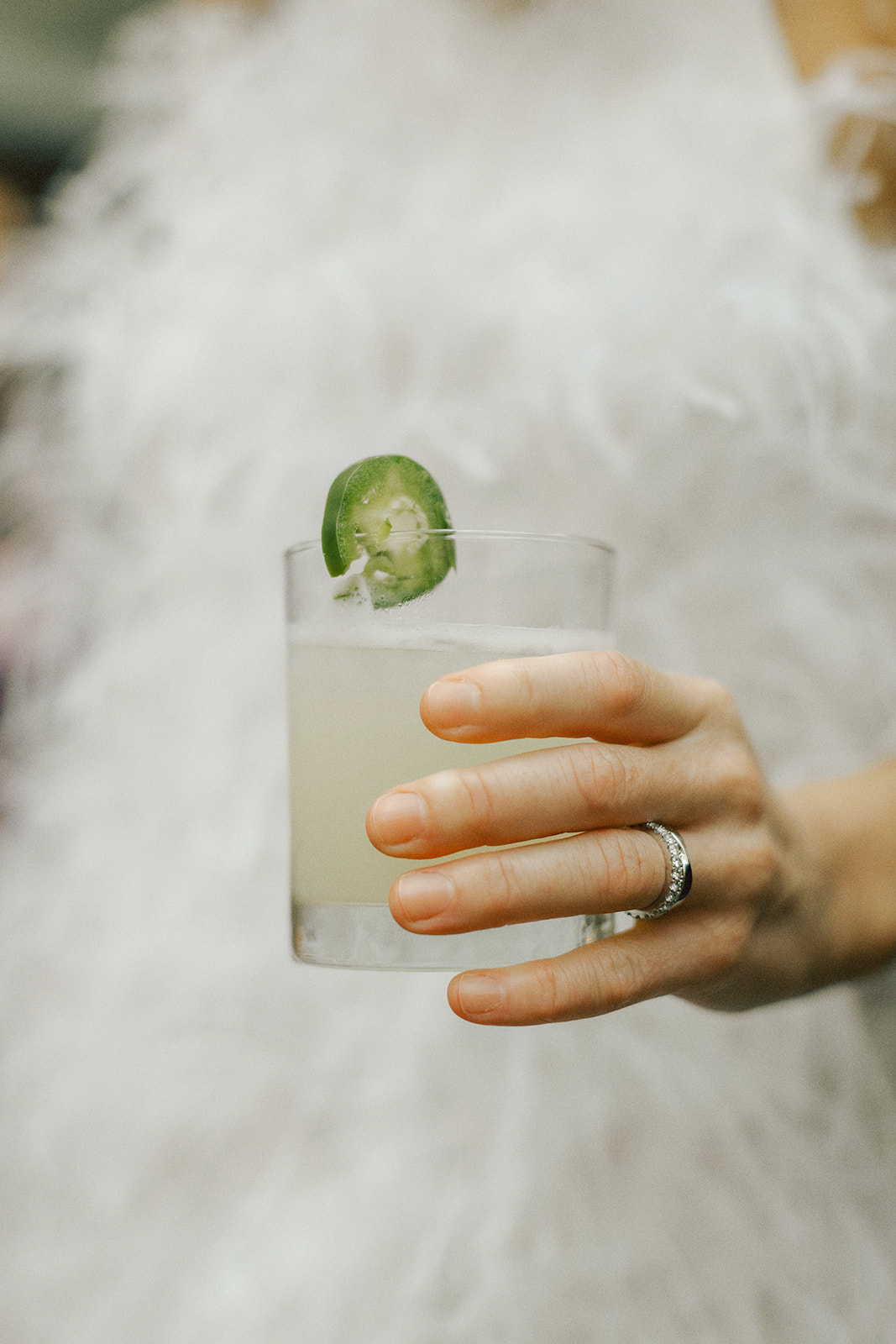 Bride holding wedding cocktail with jalapeno at her NYC wedding reception