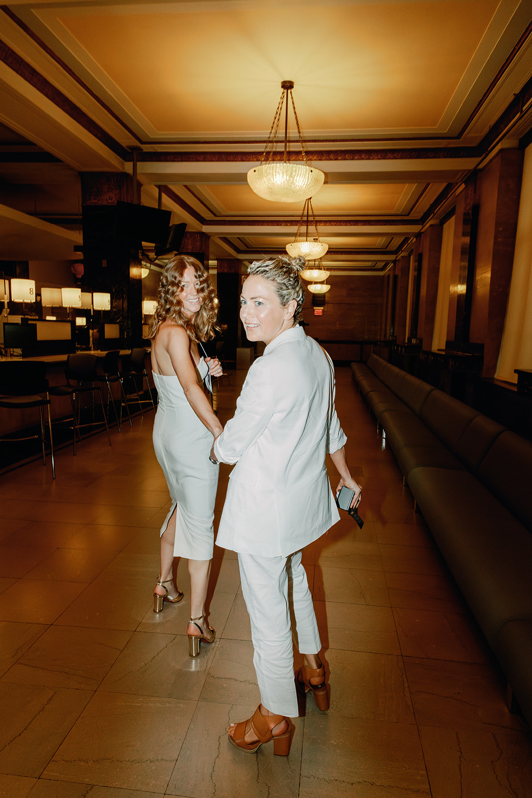 Wedding photo of same sex couple walking into New York City Hall for their civil ceremony